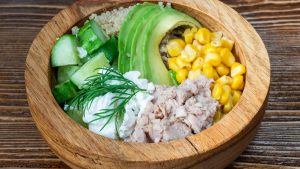 A fresh salad bowl featuring tuna, avocado, quinoa, and veggies. Perfect for a healthy meal.
