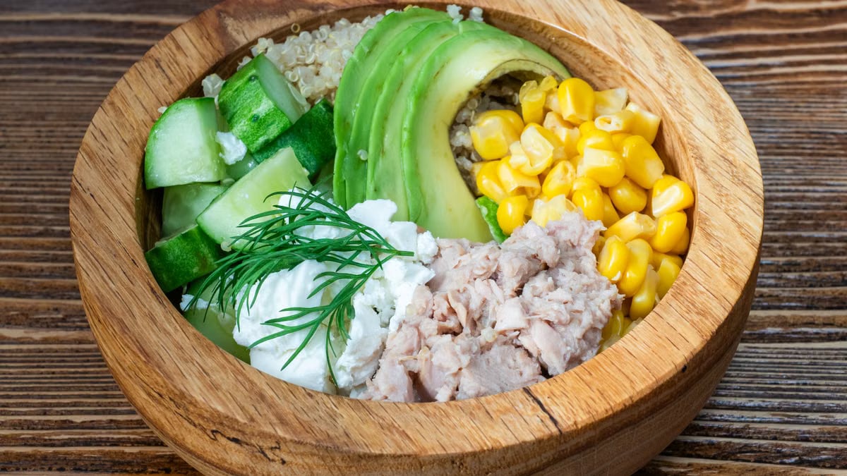A fresh salad bowl featuring tuna, avocado, quinoa, and veggies. Perfect for a healthy meal.