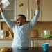 Handsome man recieve good news reading letter in the kitchen while have breakfast at home