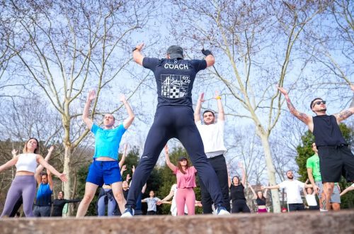 Group exercise session in a sunny Istanbul park led by a fitness coach outdoors.